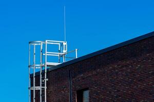 A metallic framework stands prominently on the rooftop of a brick photo