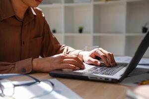 Close up of hands typing on a laptop keyboard, working on business analysis and online learning. photo