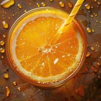 Top view of refreshing drink in glass of orange juice with drinking straw with juicy orange slice. Healthy Drink Rich in Vitamin C photo