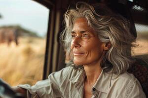 Confident mature woman in a car, SUV watching elephants during a wild animal safari in the prairie. Idea adventure, freedom and connection with nature photo