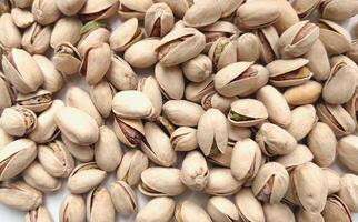 Top view of background with pistachio nuts. Appetizing dried nuts, rich in vitamins and microelements, are ready to eat. Vegetarian food photo