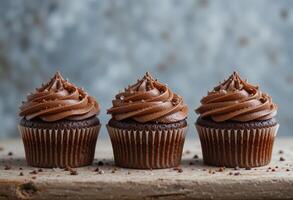Three cupcakes with chocolate. photo