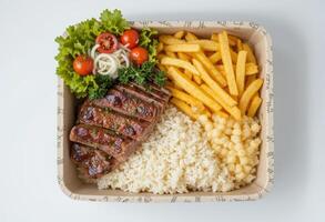 Piranha lunch box, with rice, fries, salad, top view. photo