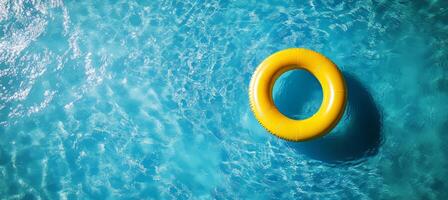 Bright Yellow Inflatable Ring Floating in a Sparkling Blue Swimming Pool on a Sunny Day photo