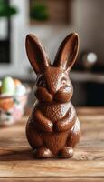 Milk Chocolate Easter Bunny on Wood Table, Spring Decor, and Blurred Candy in Background photo