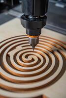 A 3d printer is cutting a spiral into a wooden board photo