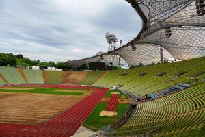 A modern stadium designed for athletics, featuring a professional running track and seating for thousands. Surrounded by trees and a river, it provides a beautiful backdrop for events. photo