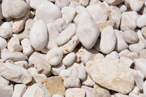 White pebbles background texture. Smooth round stones. Zen garden, spa, and meditation concept. Beach pebble stones. Perfect for a relaxing background or for use in a spa or meditation setting. photo
