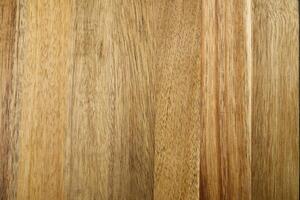 The image shows a close-up of a rich warm wood grain texture background in a light brown color. The wood grain is horizontal and has a beautiful natural pattern. photo