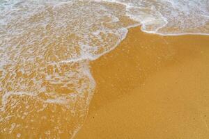 This stunning beach showcases soft golden sand and calm, clear waves gently rolling ashore. It is perfect for sunbathing, relaxation, and enjoying breathtaking views of the endless ocean horizon. photo