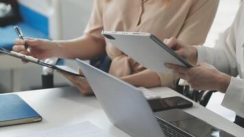 Two people sitting at a table with laptops and papers video