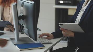 Two people sitting at a desk with a computer video
