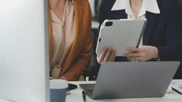 Two business people are looking at a tablet computer video