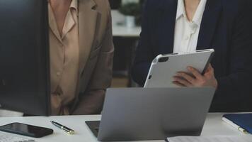 Two business people are looking at a tablet computer video