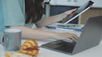 A woman using a laptop and a cup of coffee video