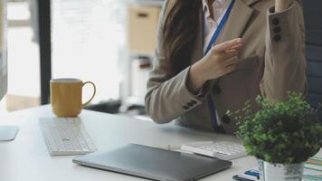 A woman in a business suit sitting at a desk with a laptop video
