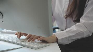 A woman typing on a keyboard at a desk video