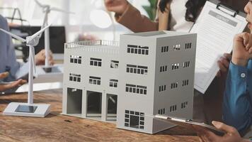 A group of people are looking at a model of a building video