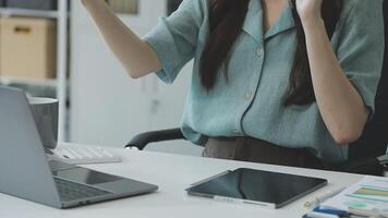 A woman sitting at a desk with her hands up video
