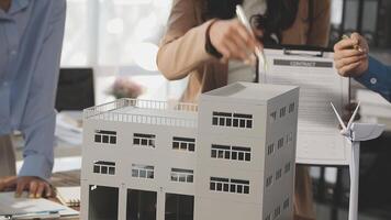 A group of people are looking at a model of a building video