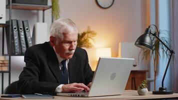 Senior businessman having software problems with laptop seeing error notification at screen at home video