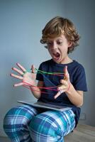 Boy screaming while playing string game photo