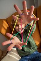 Delightful boy with multicolored strings on fingers photo
