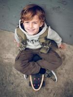 Smiling boy on skateboard on concrete ground photo