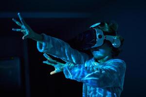 Excited kid gesturing while exploring cyberspace in VR headset photo