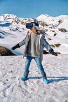 Boy playing VR game near snowy hills photo