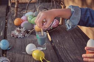 Easter eggs painted by kid on wooden table photo