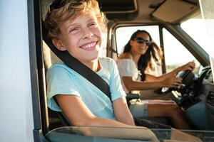 Joyful mother and kid enjoying summer journey by car photo