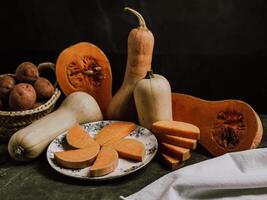 Still life of ripe nutmeg pumpkin and sliced butternut squash photo