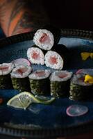 Anonymous waiter with delicious sushi rolls with salmon on tray photo