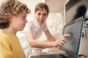 Dentists showing teeth scan to kid photo
