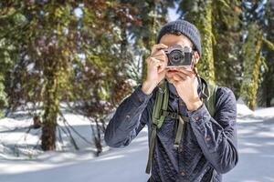 Tourist taking photo on camera while exploring nature in winter