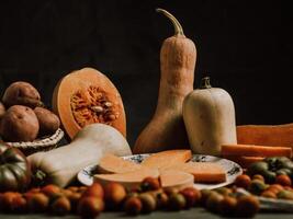 Still life of sliced pumpkin on plate and ripe tomatoes photo