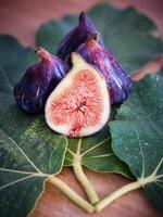 Halved and whole figs on sycamine leaves photo