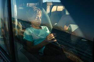 Travelling boy resting in car photo