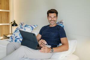 Smiling man using tablet during work on project photo