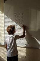 Clever pupil solving mathematical example during lesson at schoo photo