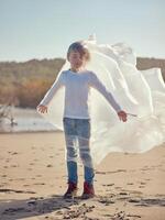 Boy with plastic bag around body on beach photo