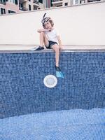 Puzzled boy in diving mask and flippers over empty pool photo