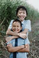 Happy kid hugging younger brother in nature photo