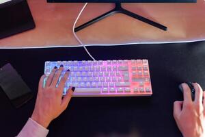 Unrecognizable person sitting with hand on keyboard and using mouse photo