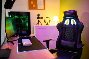 Room with computer monitor gaming PC camera and headphones with empty chair photo