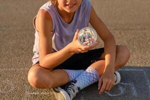Crop child with chalks in jar photo
