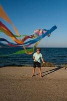 Boy having fun with kite on beach photo