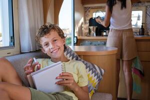 Positive boy with pen and notebook in RV photo