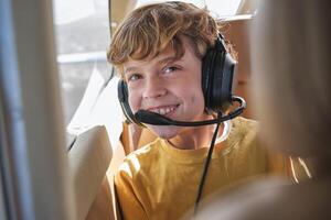 Delighted child smiling during flight in aircraft on sunny day photo